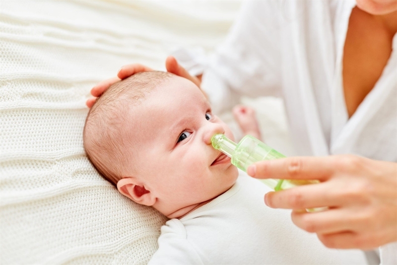 Nhỏ nước muối sinh lý để làm loãng dịch nhầy mũi của trẻ