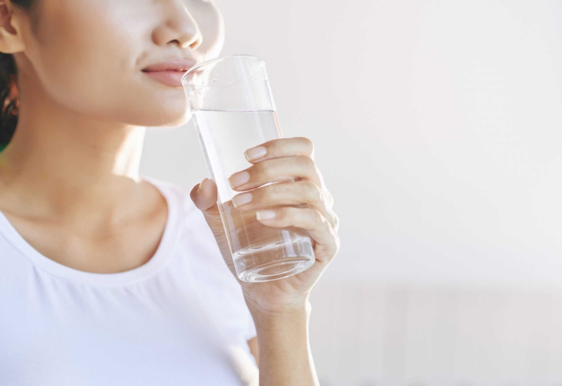 Uống đủ nước giúp giảm thiểu các triệu chứng khó chịu của sốt sau khi tiêm
