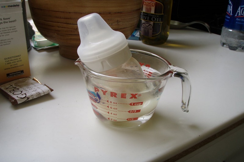 Sữa bảo quản trong tủ lạnh cần được hâm nóng trước khi cho bé uống, bằng cách đặt bình sữa vào chậu nước nóng hoặc máy hâm sữa.