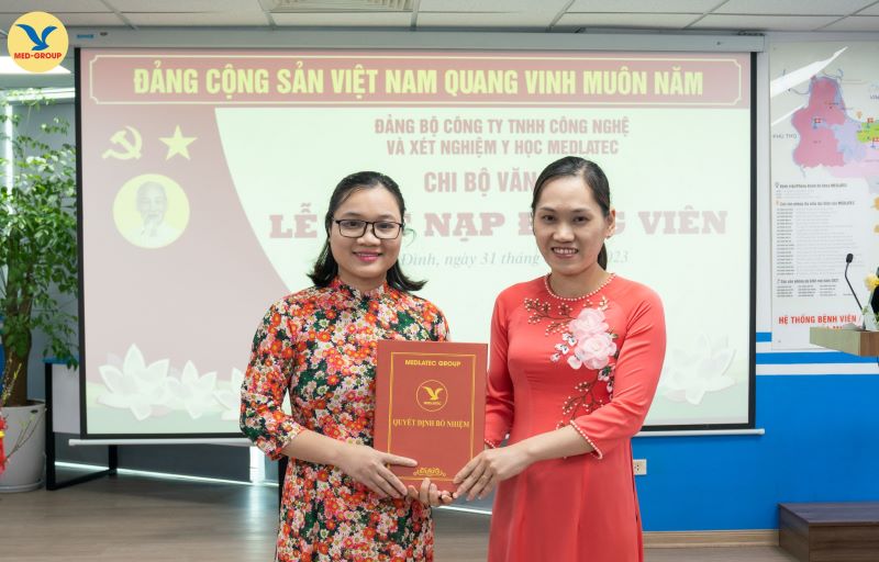 Đồng chí Trần Bích Hạnh - Bí thư Chi bộ Văn hóa trao quyết định kết nạp đảng viên của Ban Thường vụ Quận ủy Ba Đình cho quần chúng ưu tú Phan Thị Tuyết