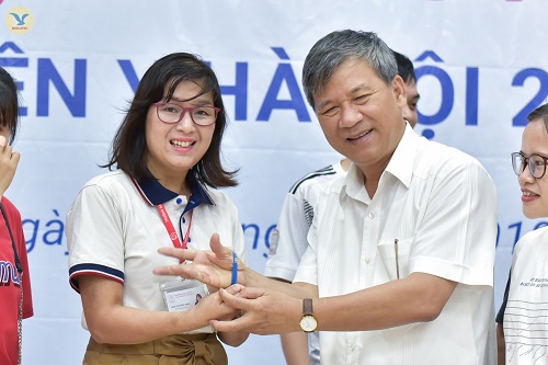 TS.BS Phan Thị Minh Ngọc, Phó Trưởng phòng Công tác chính trị và Học sinh sinh viên trao vòng kỉ niệm HMU cho GS. AHLĐ Nguyễn Anh Trí